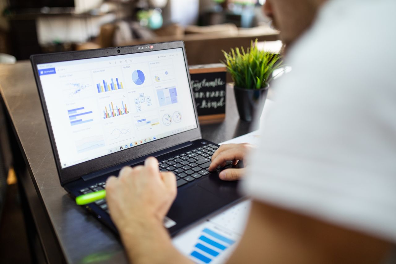 our-mission Focused business analysis with charts and graphs on a laptop in a modern office setting.